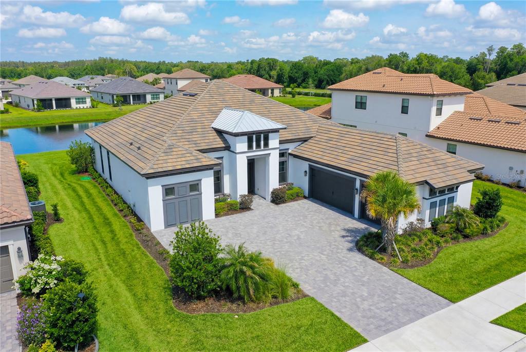 An aerial view of a single-story house with a tile roof and paved driveway — 4866 FRECCIA LOOP, WESLEY CHAPEL, FL