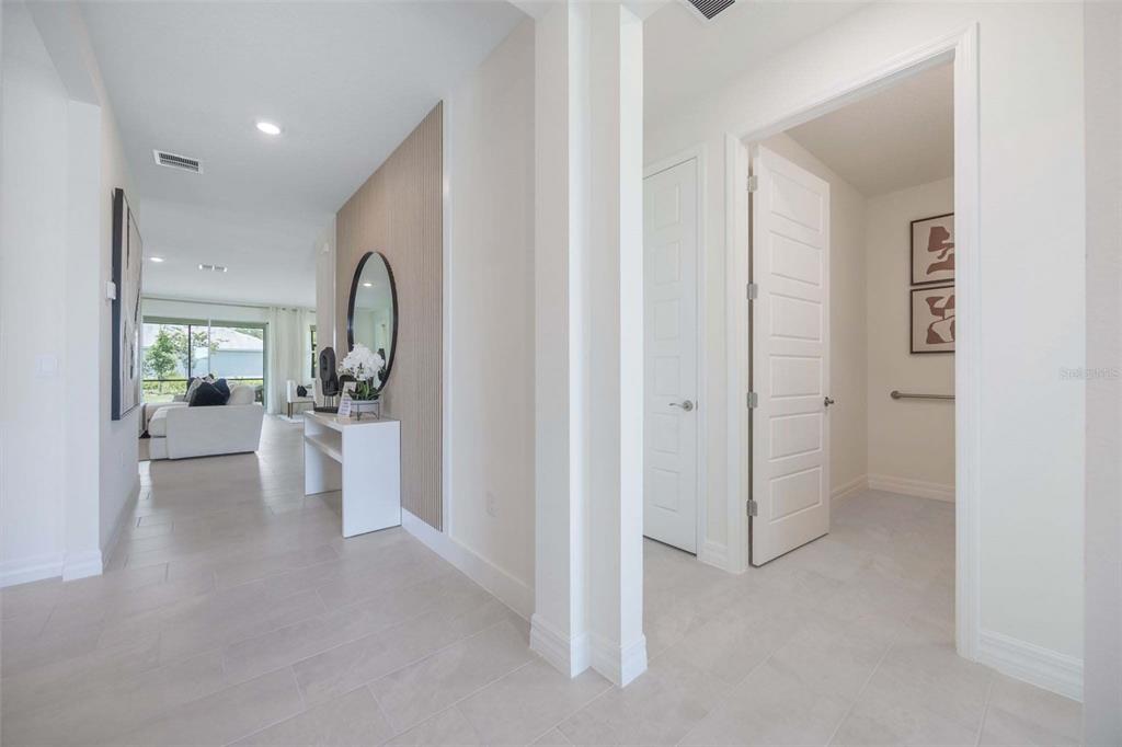 A bright entryway leads to a living area with light tile floors and wood paneling — 3949 KENNEBUNK LOOP, MOUNT DORA, FL