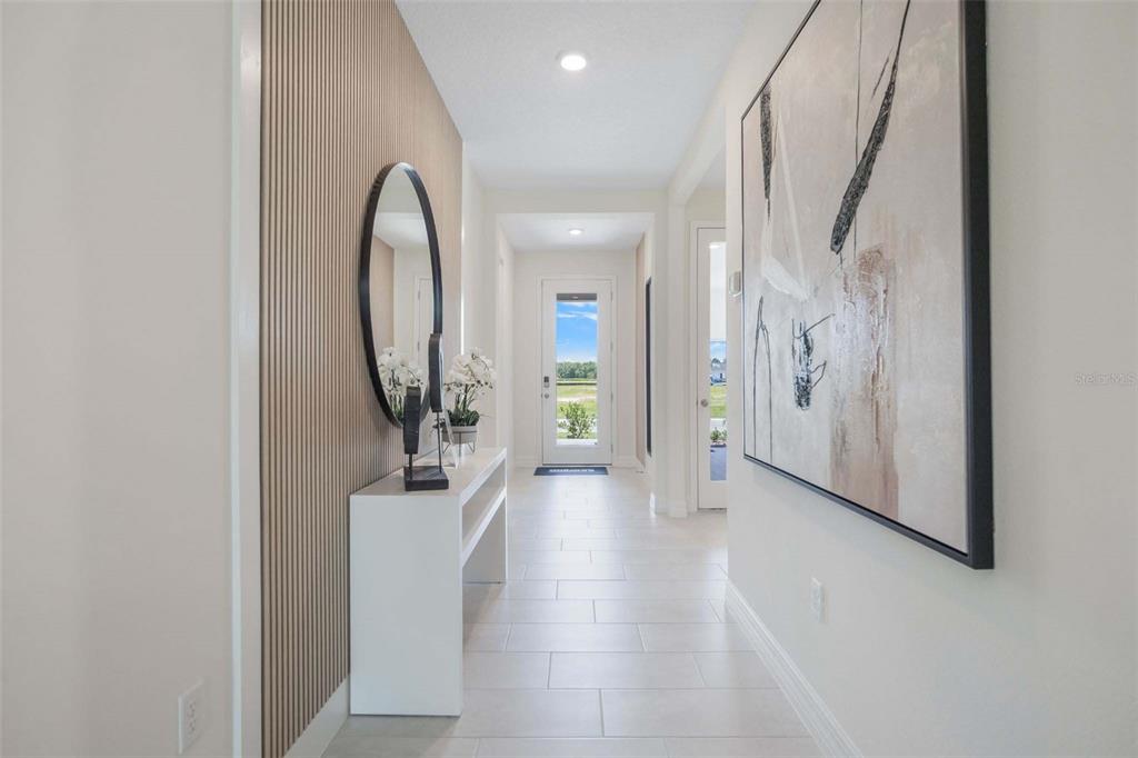 A bright hallway features a slatted wood accent wall, a console table, and large artwork — 3949 KENNEBUNK LOOP, MOUNT DORA, FL