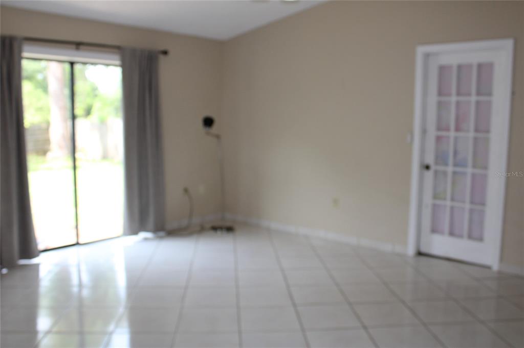 A kitchen with a breakfast bar overlooks a tiled dining area near the front entrance — 6121 56TH AVENUE N, ST PETERSBURG, FL