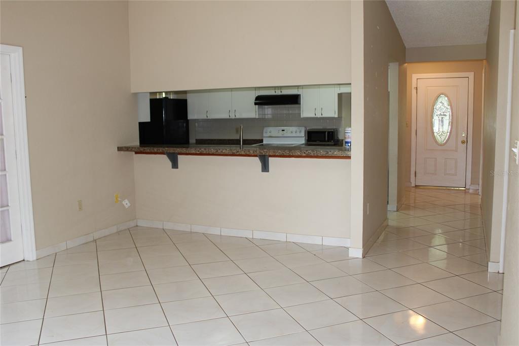 A room with white tiled floors, a sliding glass door, and a black massage chair — 6121 56TH AVENUE N, ST PETERSBURG, FL