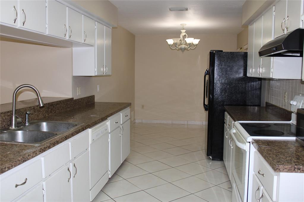 A bathroom features a white vanity, a toilet, and a bathtub with tiled walls — 6121 56TH AVENUE N, ST PETERSBURG, FL