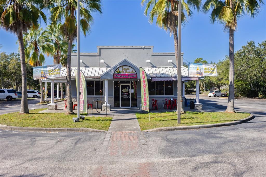 The exterior of a single-story Mexican restaurant building features a metal roof and palm trees — 8841 COMMODITY CIRCLE, ORLANDO, FL