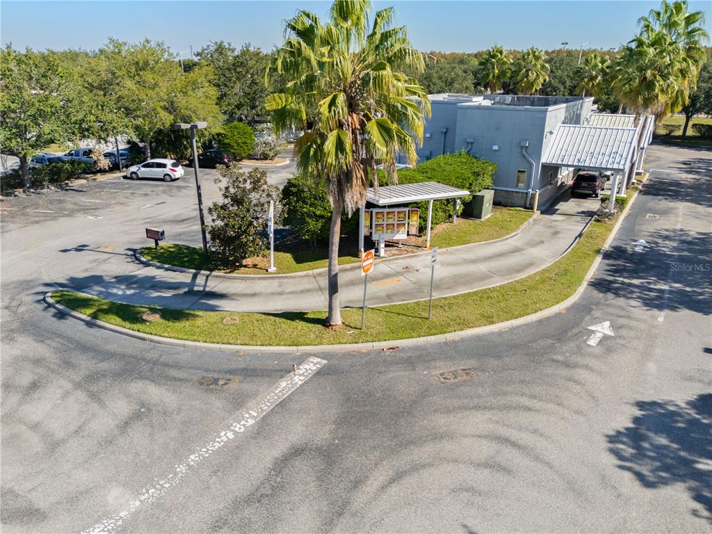 An aerial view shows a commercial building with a drive-thru lane and parking lot — 8841 COMMODITY CIRCLE, ORLANDO, FL