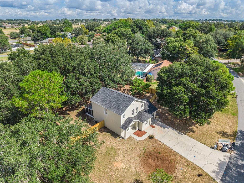 An aerial view shows a two-story house with a driveway and surrounding trees — 11424 MANDARIN DRIVE, CLERMONT, FL