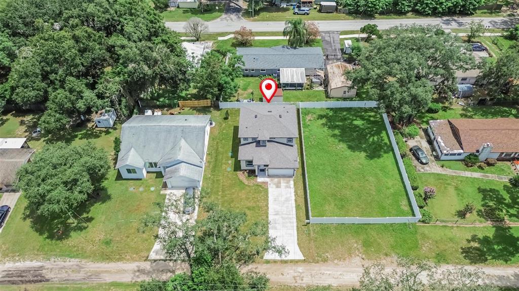 An aerial view shows a two-story house with a concrete driveway and a fenced yard — 11521 HIGDON DRIVE, THONOTOSASSA, FL