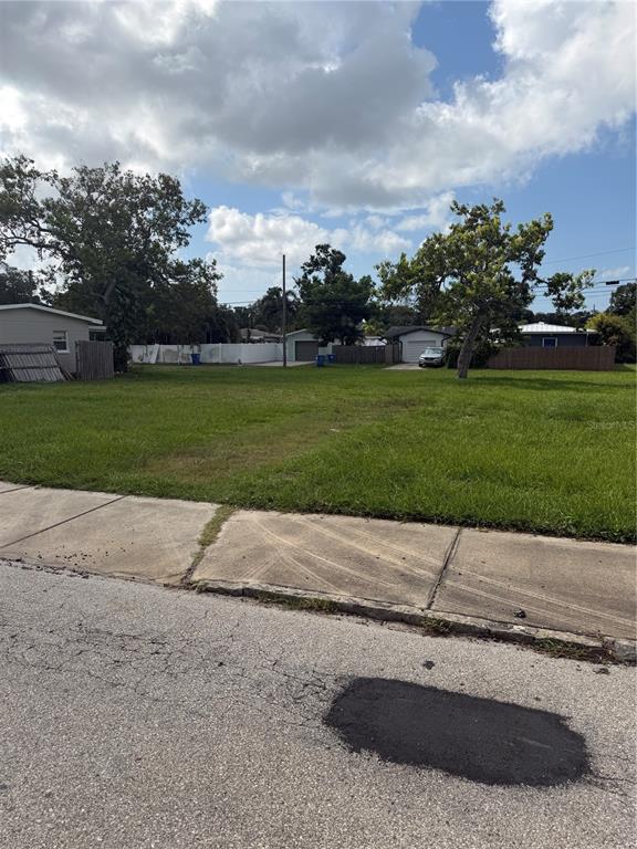 A vacant, grassy residential lot sits between two houses along a paved street — 5358 9TH AVENUE N, ST PETERSBURG, FL