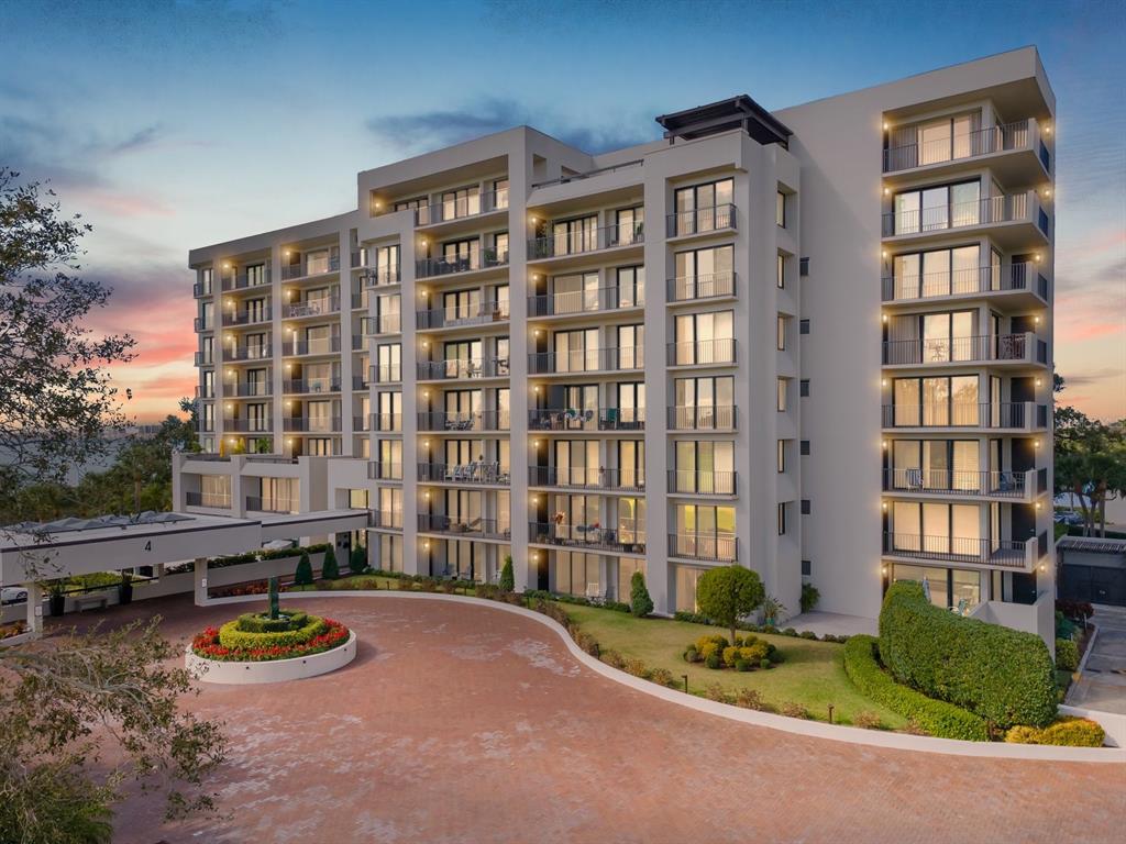 A multi-story residential building with balconies and a circular driveway at sunset — 4 BELLEVIEW BOULEVARD UNIT 804, BELLEAIR, FL