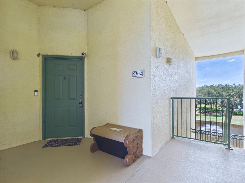 A living room features a tan sofa, a blue sofa, and a glass-topped coffee table — 8816 DUNES COURT UNIT 302, KISSIMMEE, FL