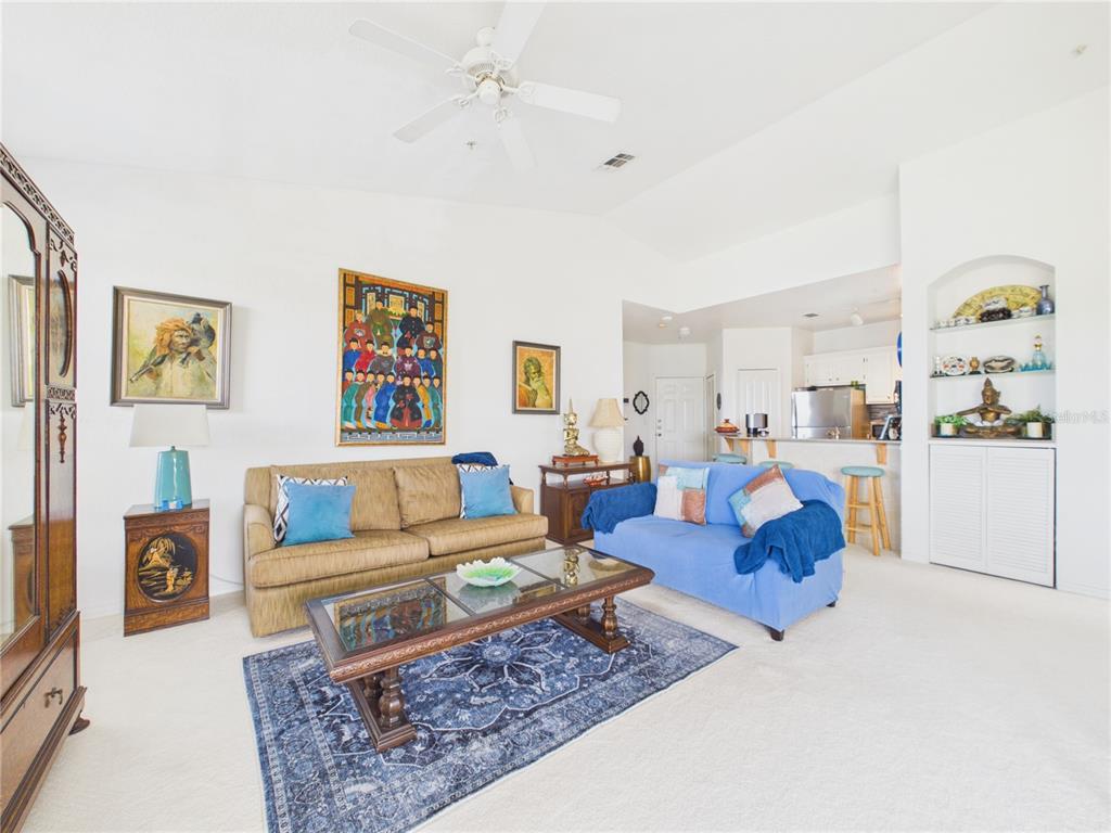 A bright entryway features a white door, a closet with louvered doors, and a round rug — 8816 DUNES COURT UNIT 302, KISSIMMEE, FL
