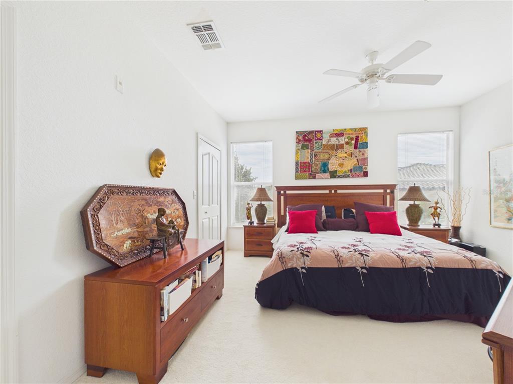 A bedroom features two twin beds with floral bedding, a ceiling fan, and a window — 8816 DUNES COURT UNIT 302, KISSIMMEE, FL