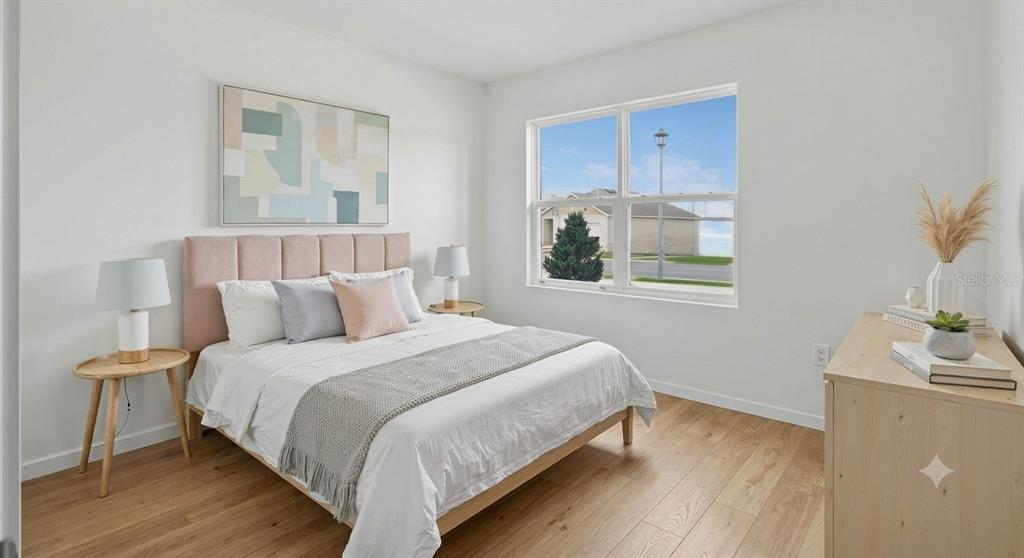 A bedroom features a pink upholstered headboard, light wood flooring, and a large window — 1641 REDDISH EGRET COURT, DAVENPORT, FL