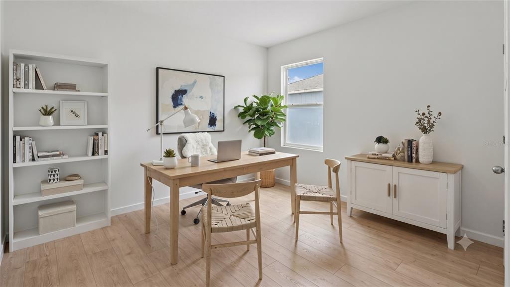 A home office features a wooden desk, two woven chairs, a bookshelf, and a white cabinet — 1641 REDDISH EGRET COURT, DAVENPORT, FL