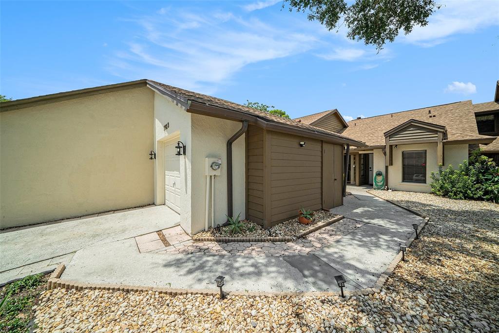 A beige exterior home with a brown storage shed and a concrete walkway — 1923 BAYSHORE COURT, SAFETY HARBOR, FL