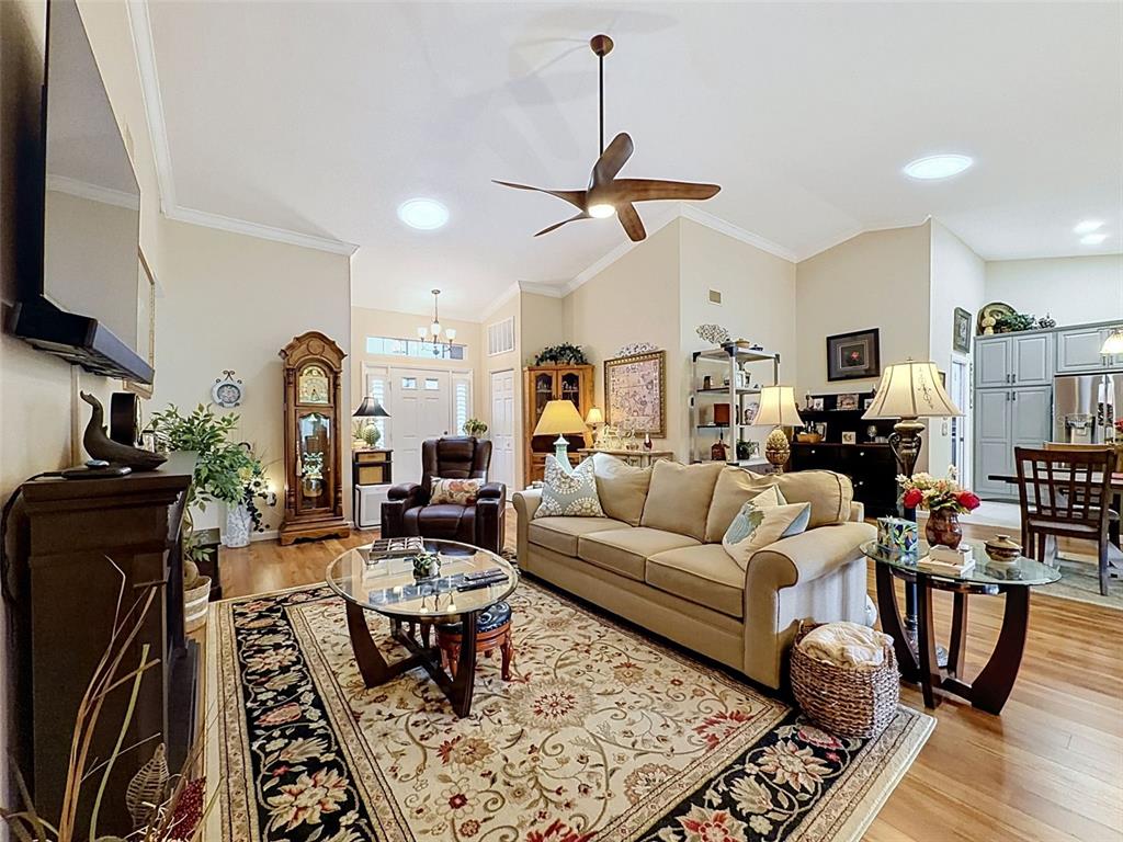 A living room features hardwood floors, a brown leather recliner, and a fireplace with television — 18412 BENT PINE DRIVE, HUDSON, FL