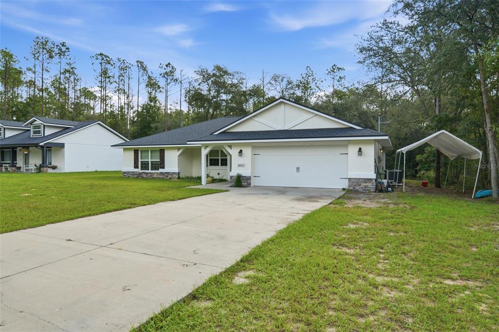 A single-story house with a white exterior, a two-car garage, and a concrete driveway — 8683 N TEATHER TERRACE, CITRUS SPRINGS, FL