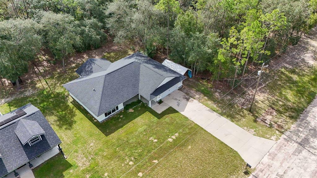 An aerial view shows a single-story house with a gray roof and a concrete driveway — 8683 N TEATHER TERRACE, CITRUS SPRINGS, FL