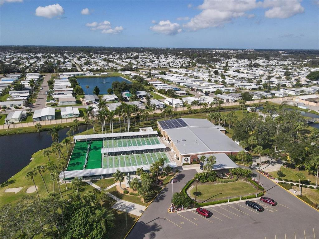 An aerial view shows a community center with tennis courts, a pond, and parking — 4917 1ST A STREET E, BRADENTON, FL