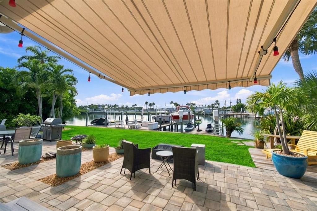A boat lift holds a red boat over a dock with kayaks and a ladder — 245 116TH AVENUE UNIT 245, TREASURE ISLAND, FL