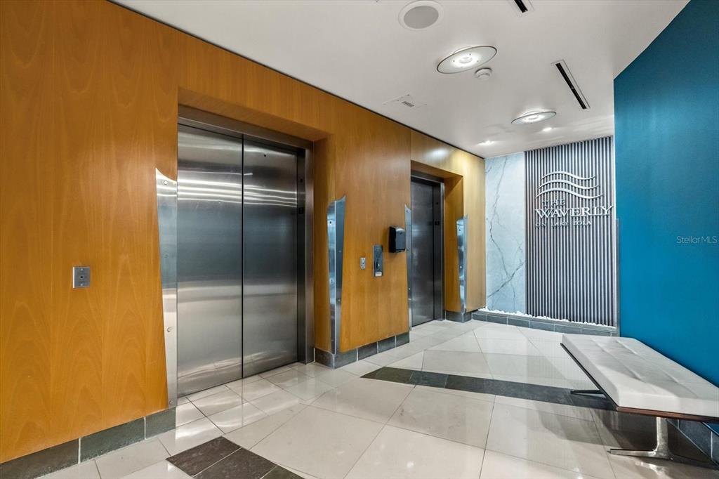 A bathroom featuring a glass-enclosed walk-in shower with marble-look tile and a toilet — 322 E CENTRAL BOULEVARD UNIT 710, ORLANDO, FL