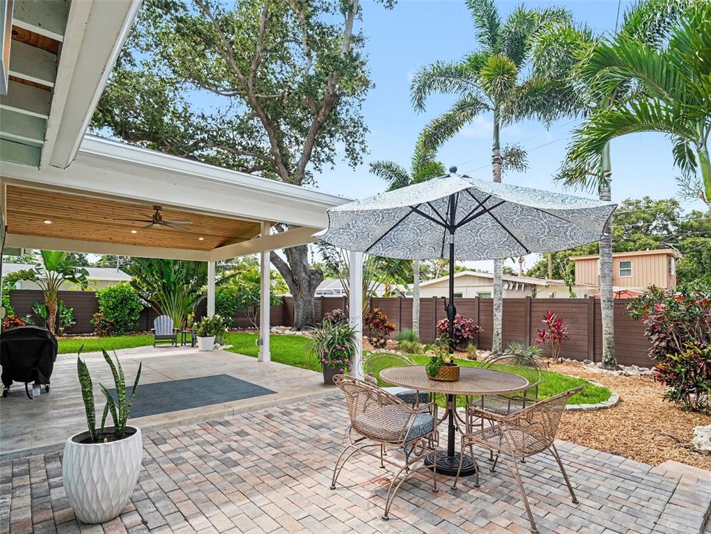 A single-story house with a paved driveway, palm tree, and large oak tree at sunset — 2344 TEMPLE STREET, SARASOTA, FL