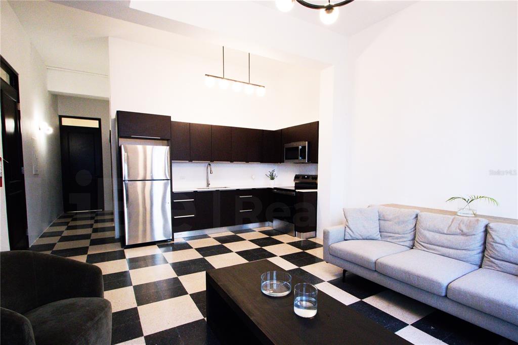 An open-concept living room and kitchen with black and white checkered tile flooring — 254-256 SAN FRANCISCO STREET UNIT 202, SAN JUAN, PR