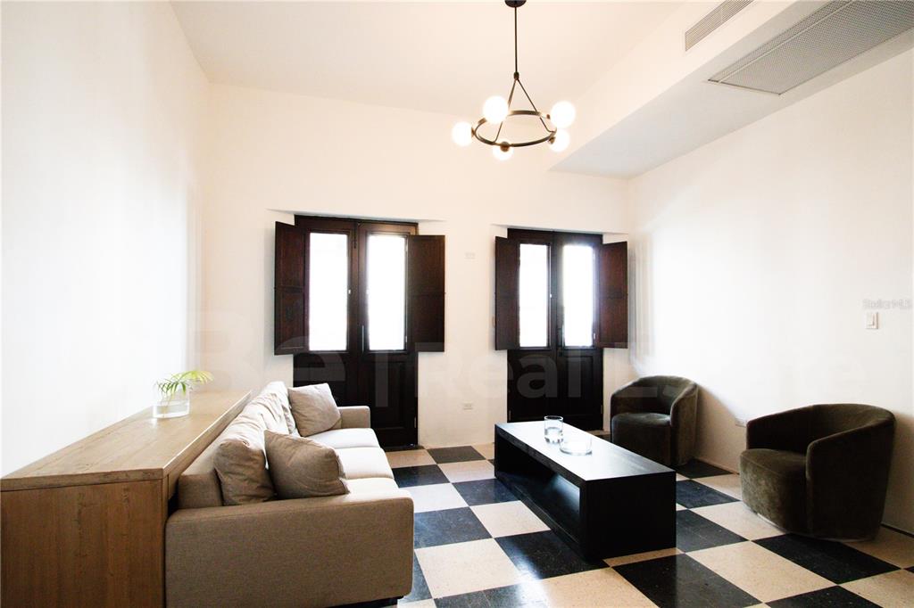 A living room features a black and white checkered floor, a sofa, and two armchairs — 254-256 SAN FRANCISCO STREET UNIT 202, SAN JUAN, PR