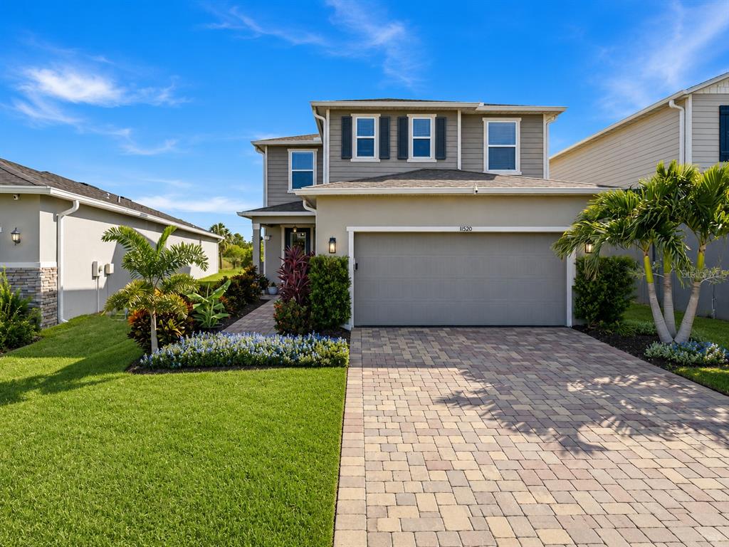 A two-story house with a gray garage, tan siding, and a paved driveway — 11520 GALLATIN TRAIL, PARRISH, FL
