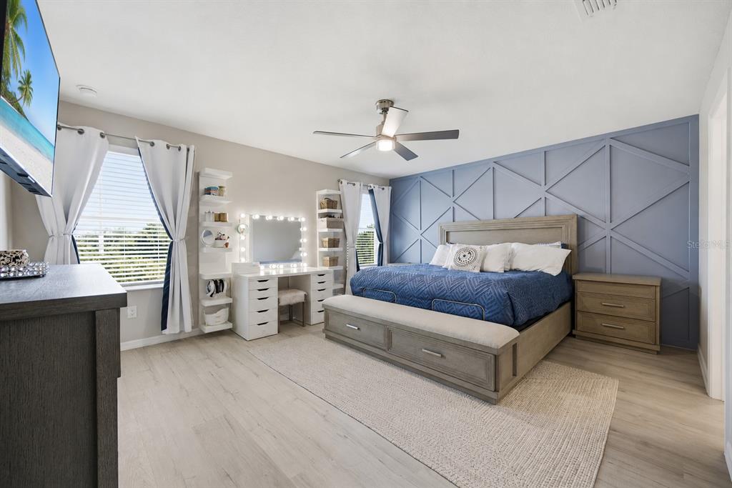 A bedroom features a blue accent wall, a bed with a bench, and a vanity station — 11520 GALLATIN TRAIL, PARRISH, FL