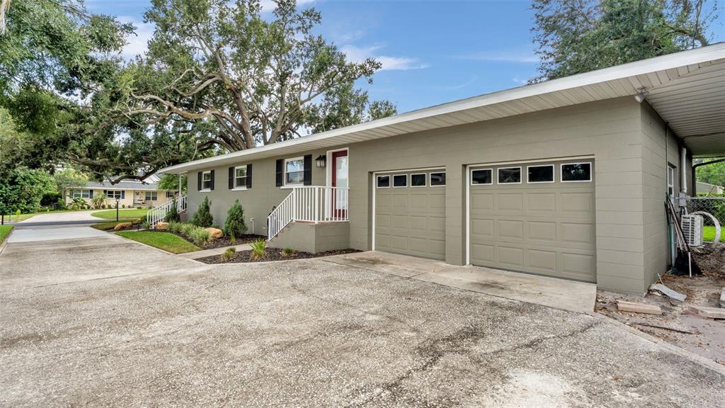 A single-story house with a two-car garage, concrete driveway, and a small front porch — 1522 DEL CREST PLACE, LAKELAND, FL