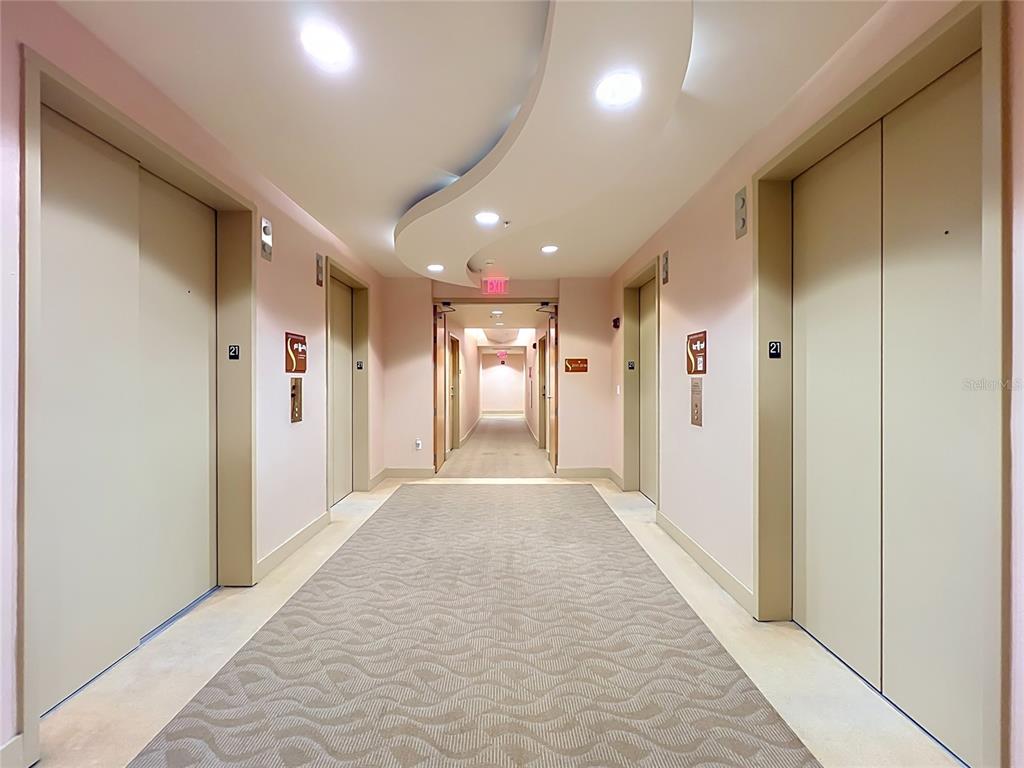 A bedroom features a patterned ceiling, a bed with gray bedding, and a partial wall — 155 S COURT AVENUE UNIT 2107, ORLANDO, FL