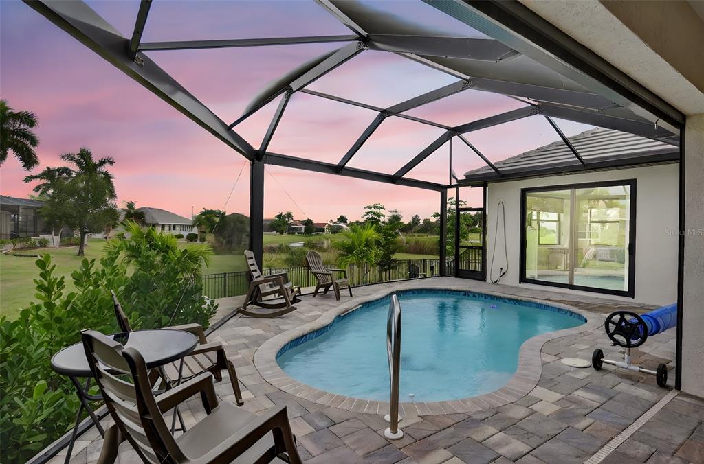 A screened-in patio features a small swimming pool, patio furniture, and a sunset view — 609 MONACO DRIVE, PUNTA GORDA, FL