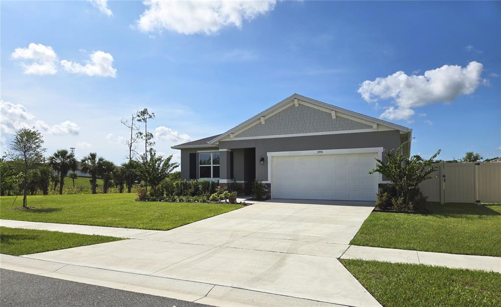 A single-story gray house with a white garage door and a concrete driveway — 3995 CAYMAN DRIVE, TITUSVILLE, FL