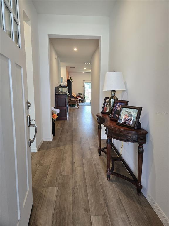 A view from an open front door into a hallway with wood-look tile flooring — 3995 CAYMAN DRIVE, TITUSVILLE, FL