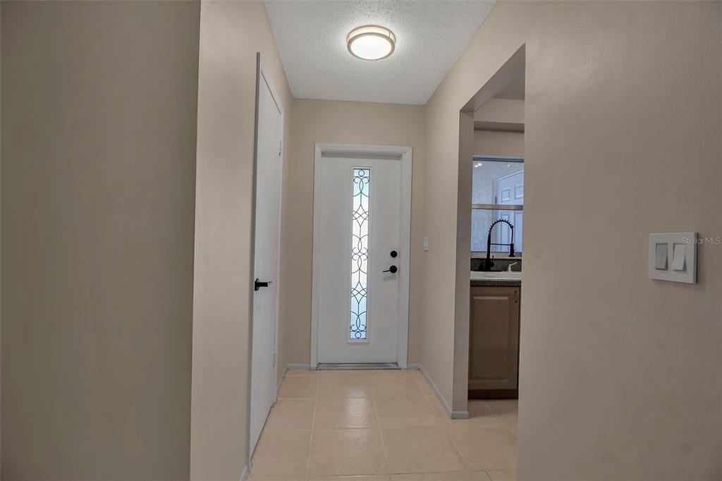 A tiled entryway features a white front door with a decorative glass insert — 3212 RAMBLEWOOD DRIVE N UNIT 3212, SARASOTA, FL