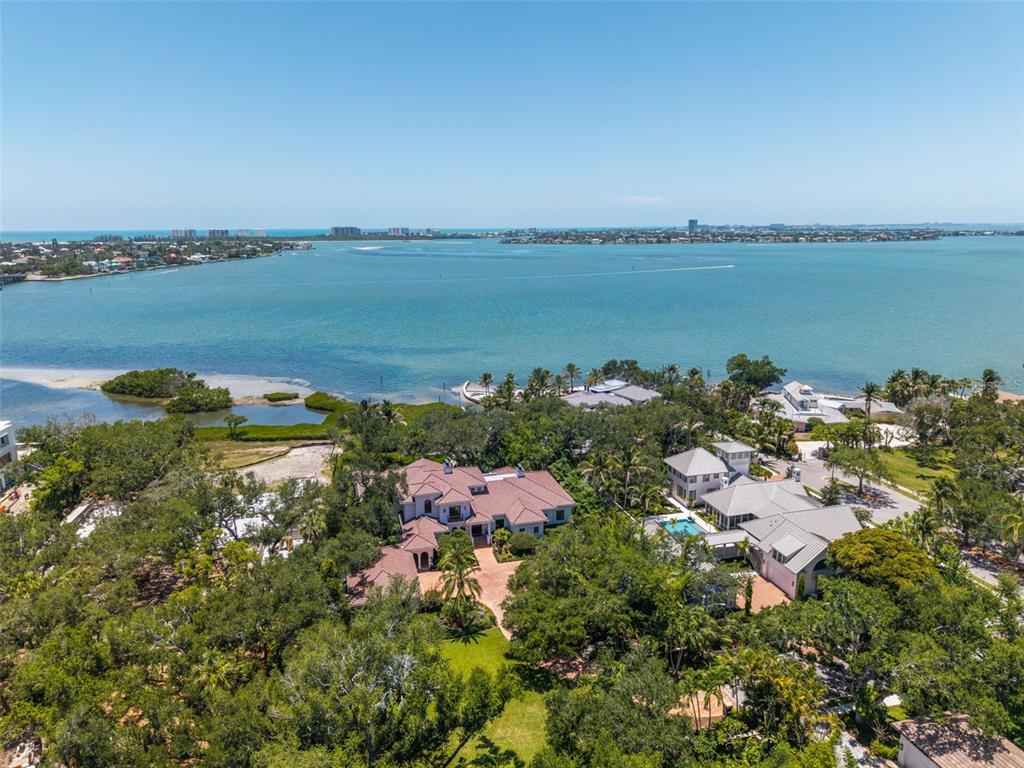 An aerial view shows two large waterfront houses surrounded by trees near a bay — 3000 SOUTHWEST DRIVE, SARASOTA, FL