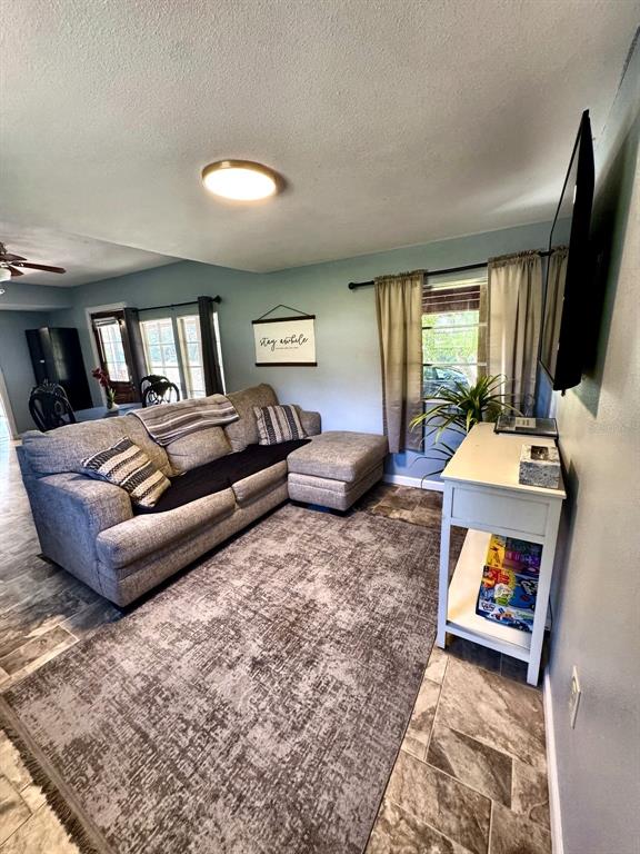 A living room features a gray sectional sofa, a patterned area rug, and a white console — 6838 N CARL G ROSE HIGHWAY, HERNANDO, FL