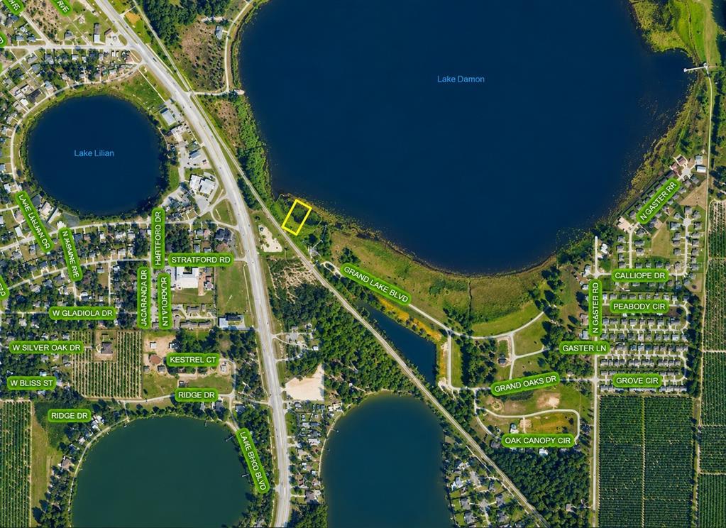 An aerial view shows a swimming pool, a covered patio, and a wooden dock on a lake — 994 GRAND LAKE BOULEVARD, AVON PARK, FL