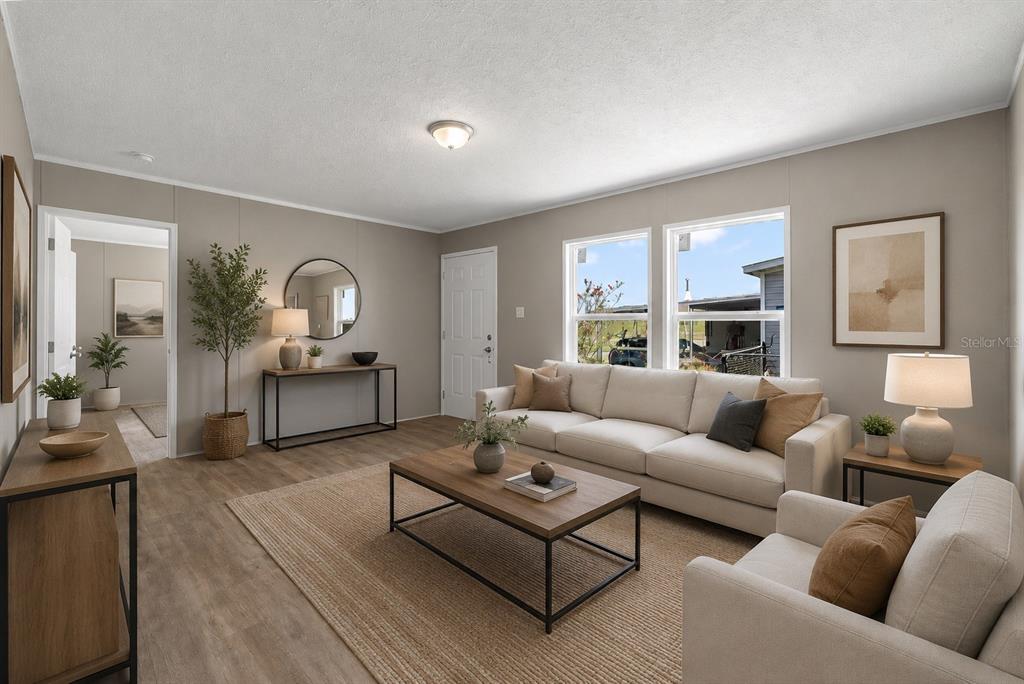 A living room features a beige sofa, a wooden coffee table, and light wood flooring — 25124 HUCKLEBERRY WAY, ASTATULA, FL