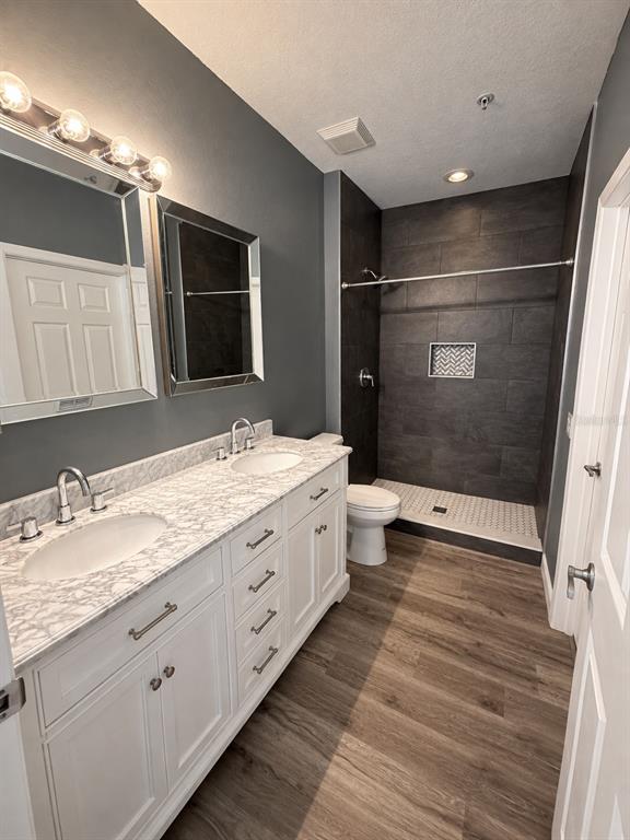 A bathroom features a double vanity with a marble countertop, gray walls, and a walk-in shower — 2388 GRAND CENTRAL PARKWAY UNIT 8, ORLANDO, FL