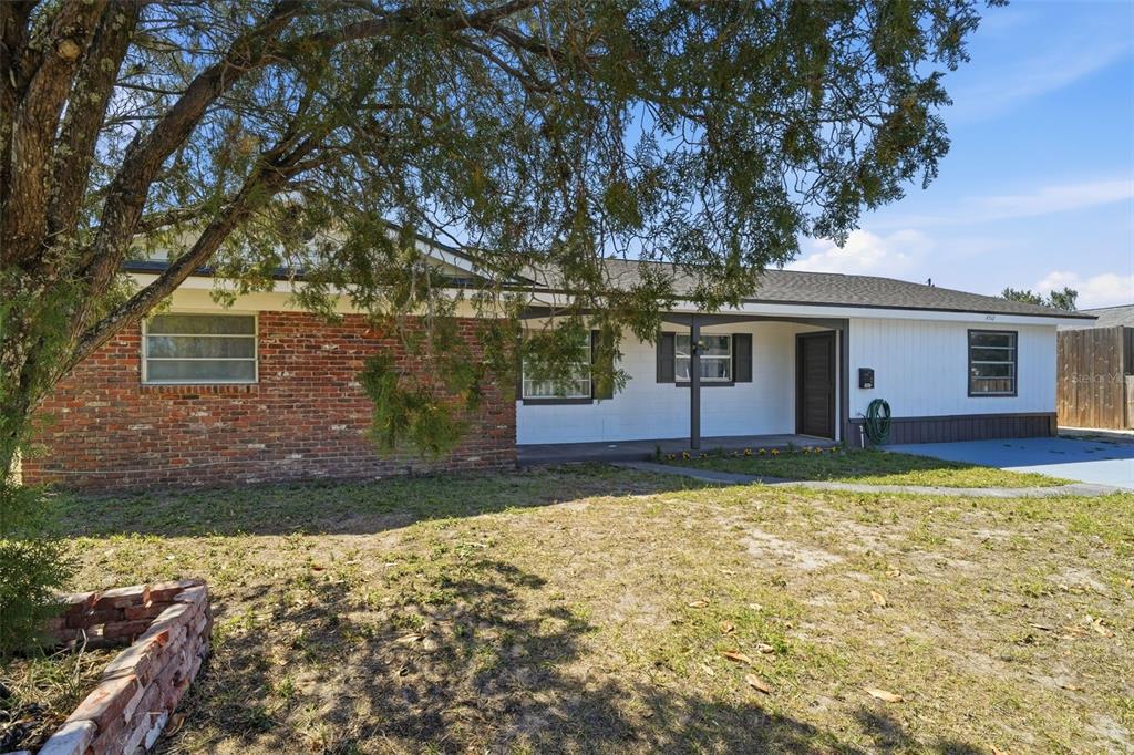 A single-story house features a brick facade, white siding, and a covered front porch — 4510 FETROW DRIVE, ORLANDO, FL