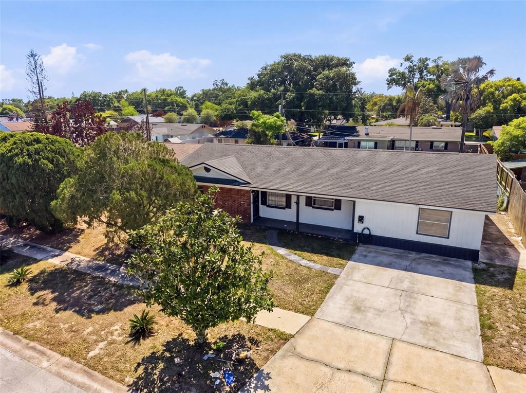 An aerial view of a single-story house with a white exterior, brick accents, and driveway — 4510 FETROW DRIVE, ORLANDO, FL