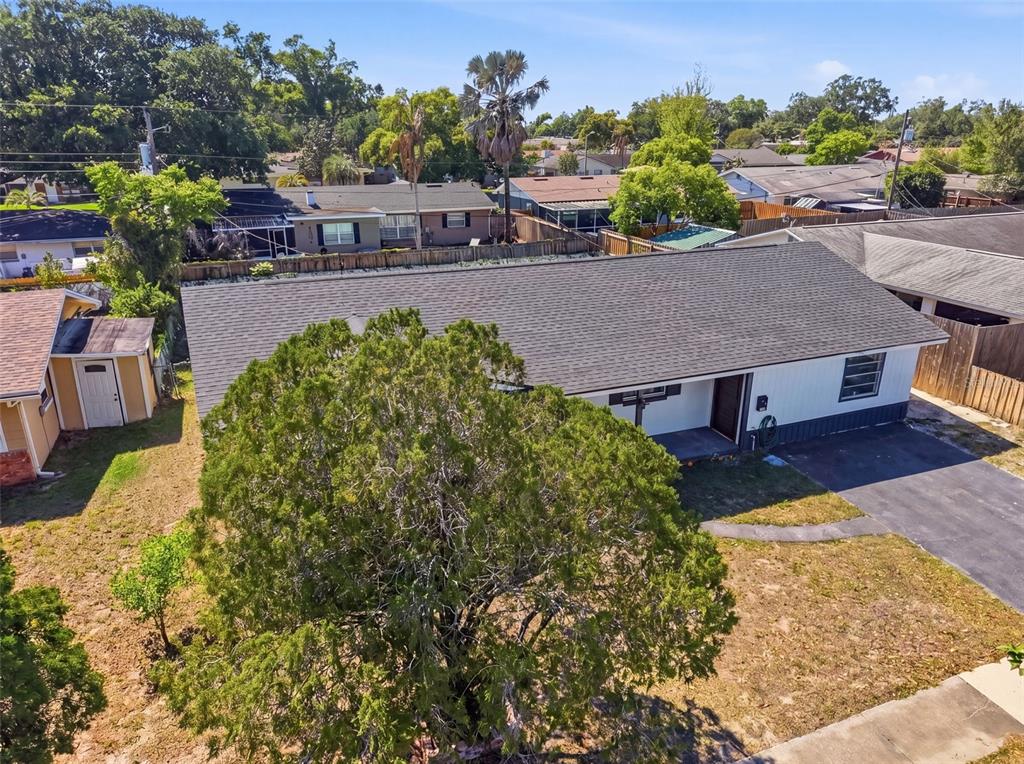 An aerial view shows a single-story house with a dark roof, driveway, and large tree — 4510 FETROW DRIVE, ORLANDO, FL