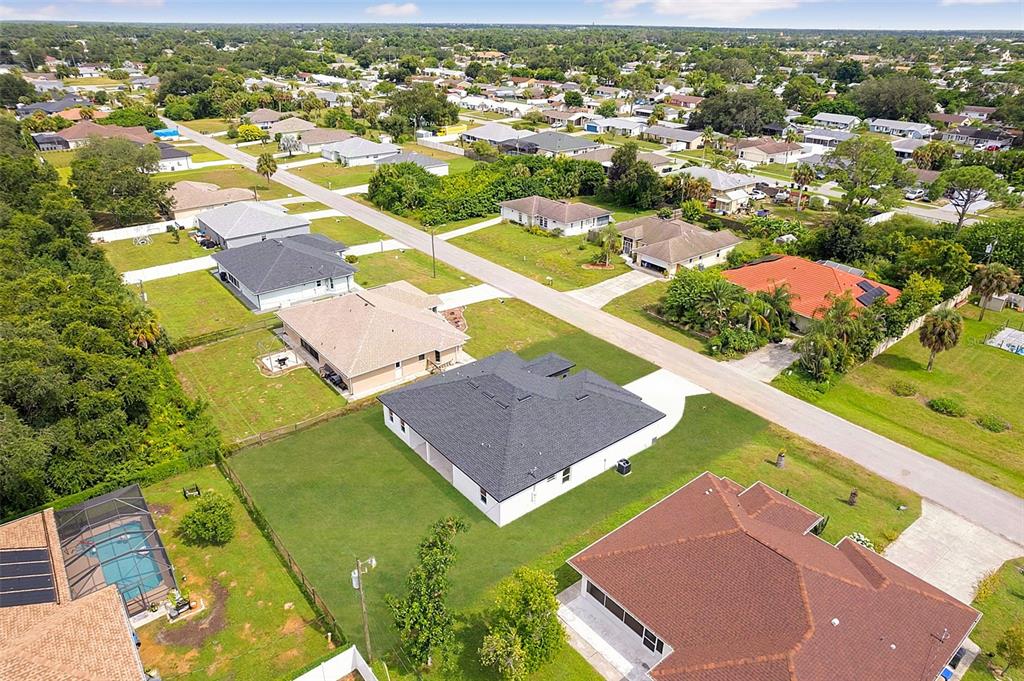 An aerial view shows several suburban houses with yards and driveways in a residential neighborhood — 8274 MOSSBORGER AVENUE, NORTH PORT, FL