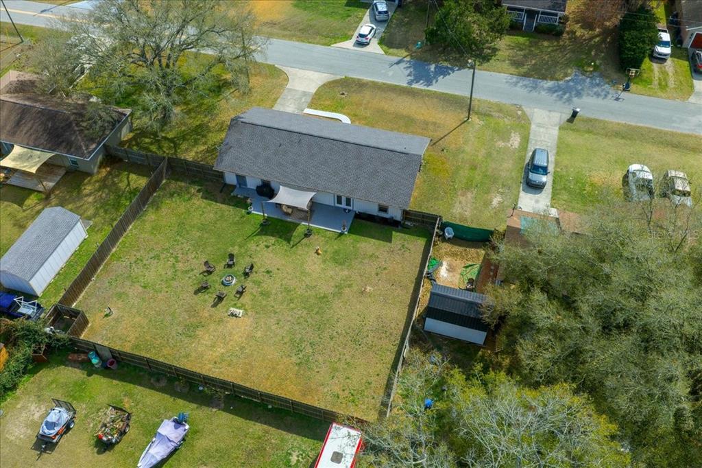 An aerial view shows a house with a fenced backyard, a patio, and a fire pit — 685 NW 67TH PLACE, OCALA, FL