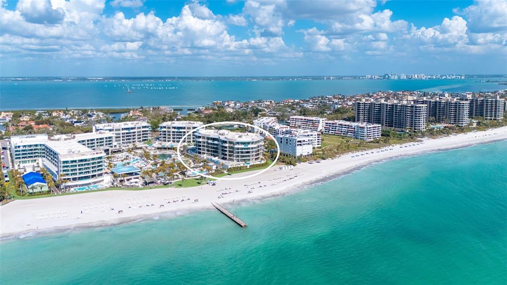 An aerial view of a beachfront resort complex with a circled multi-story building — 1561 GULF OF MEXICO DRIVE UNIT 304, LONGBOAT KEY, FL