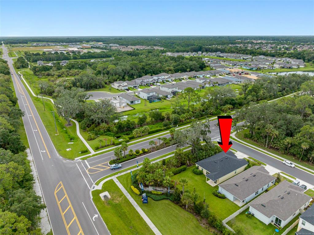 An aerial view shows a suburban house with a red arrow pointing to its roof — 11234 HIGH NOON TRAIL, PARRISH, FL