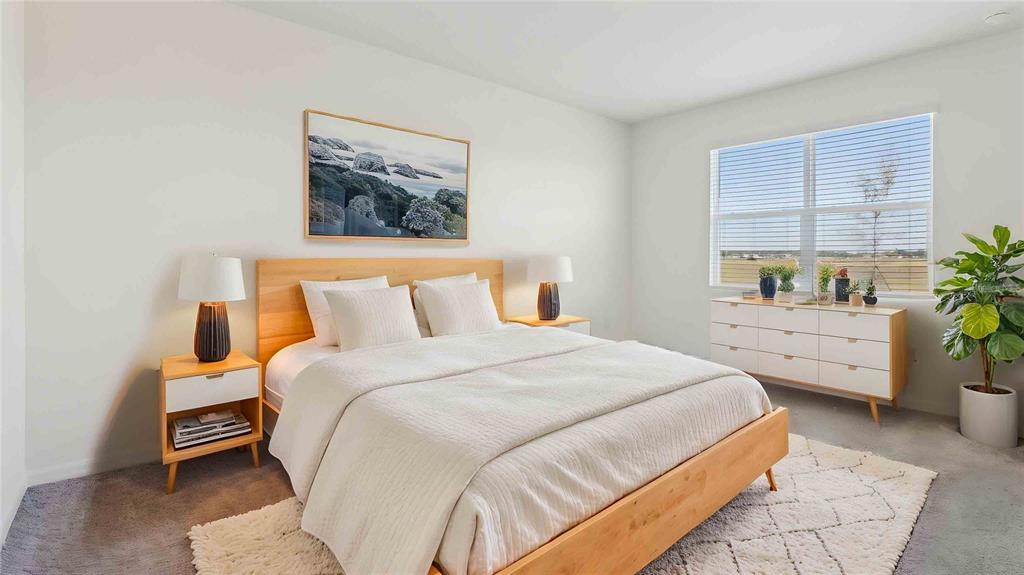 A bedroom features a wooden bed frame, white bedding, two nightstands, and a white dresser — 3036 CANOPY OAK BOULEVARD, WILDWOOD, FL