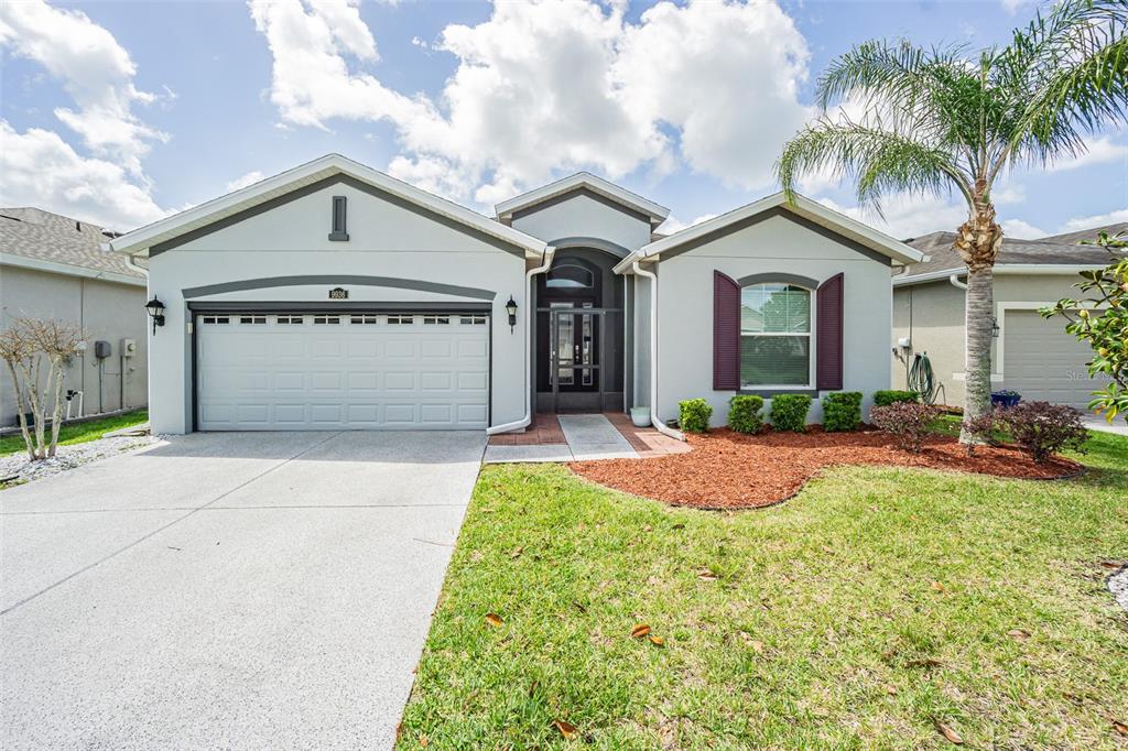 A single-story house with a two-car garage, a palm tree, and a front entryway — 9936 GAP WEDGE DRIVE, SAN ANTONIO, FL