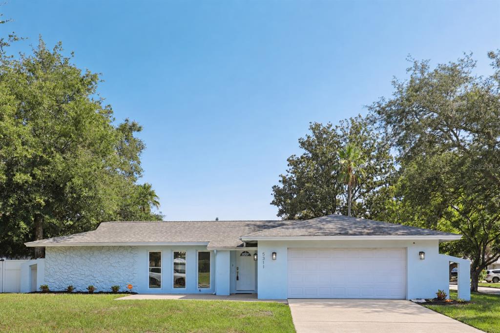 A light blue, single-story house with a two-car garage and a concrete driveway — 5311 JENNIFER PLACE, ORLANDO, FL
